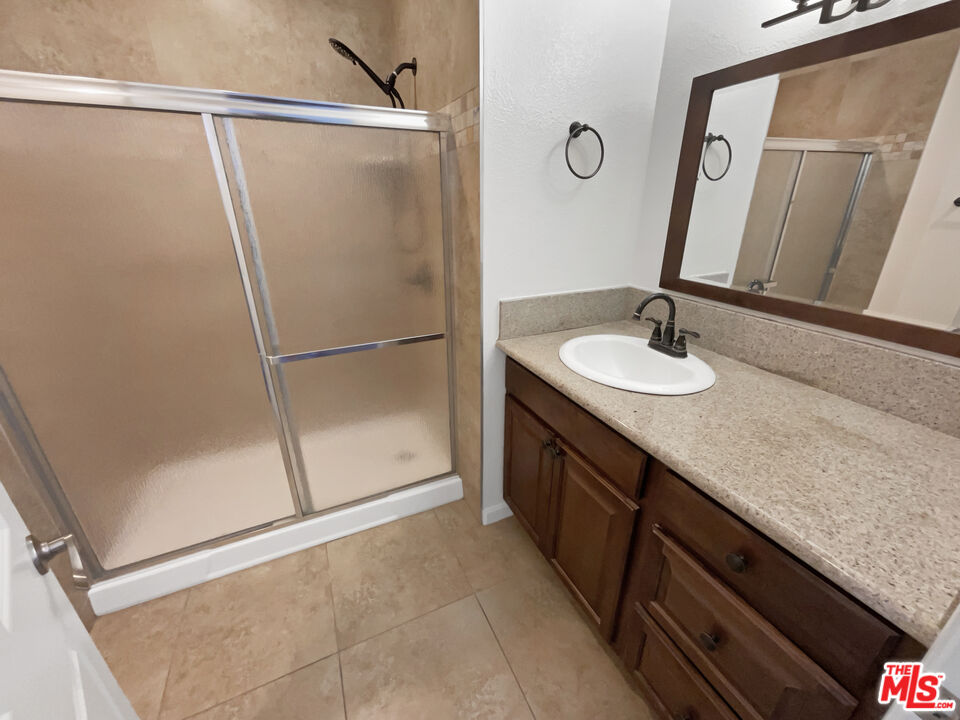 17530 Devonshire Street Northridge, CA 91325 - Photo 11 of 39 a bathroom with a granite countertop sink and a mirror