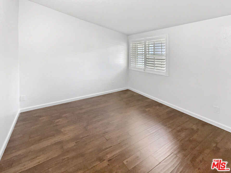 17530 Devonshire Street Northridge, CA 91325 - Photo 17 of 39 an empty room with wooden floor and windows