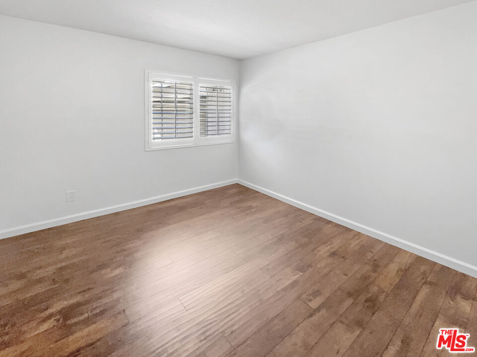 17530 Devonshire Street Northridge, CA 91325 - Photo 19 of 39 an empty room with wooden floor and windows
