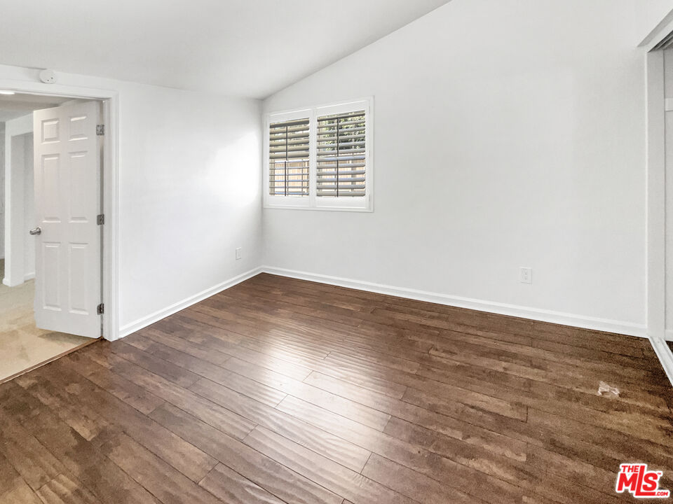 17530 Devonshire Street Northridge, CA 91325 - Photo 21 of 39 an empty room with wooden floor and windows
