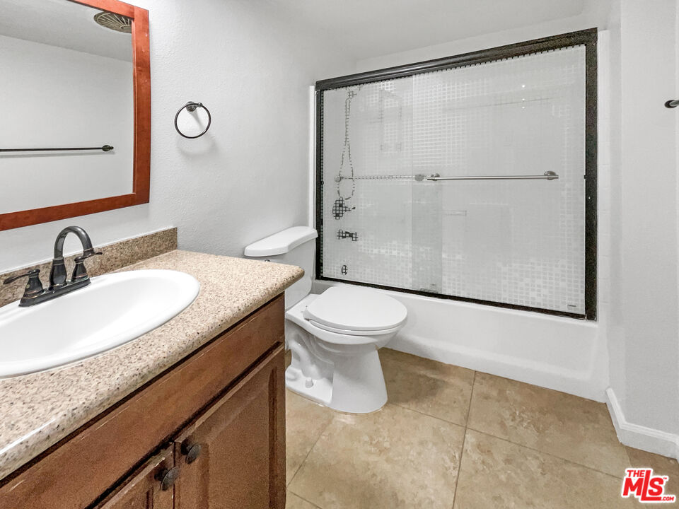 17530 Devonshire Street Northridge, CA 91325 - Photo 23 of 39 a bathroom with a granite countertop sink toilet and shower