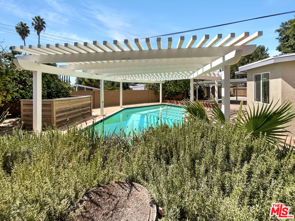 17530 Devonshire Street Northridge, CA 91325 - Photo 35 of 39 a view of a house with a big yard potted plants and large tree