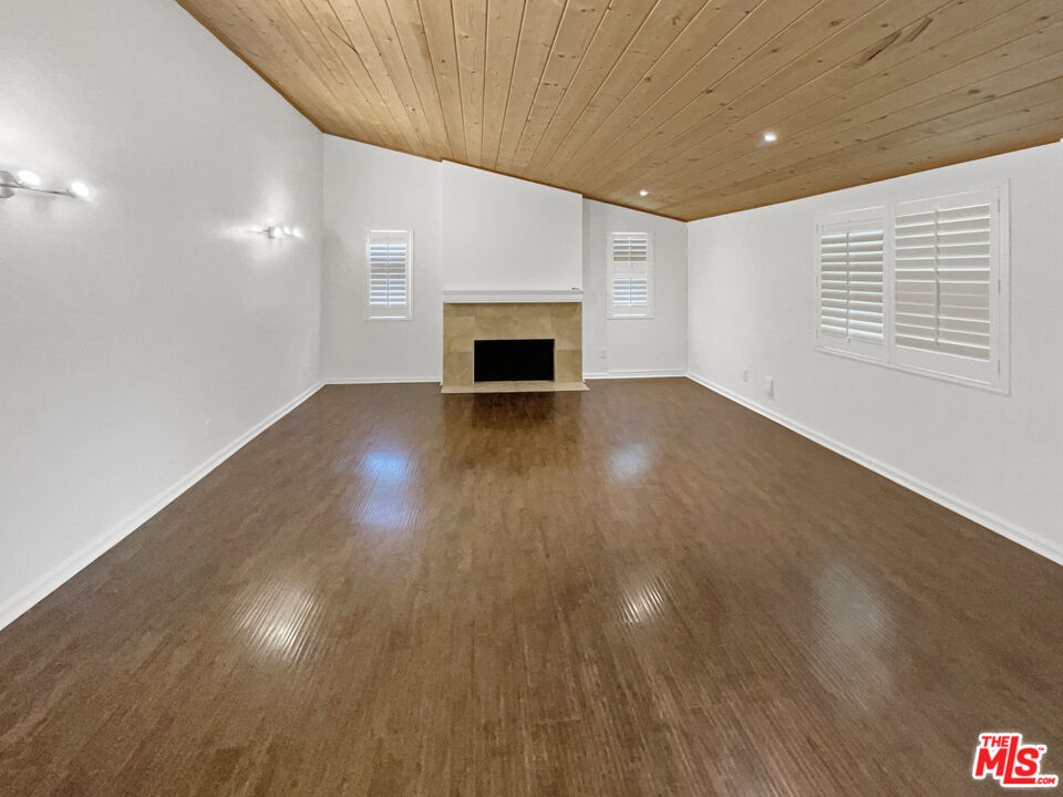 17530 Devonshire Street Northridge, CA 91325 - Photo 4 of 39 a view of an empty room with wooden floor and a window