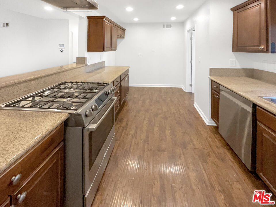 17530 Devonshire Street Northridge, CA 91325 - Photo 8 of 39 a kitchen with a stove and a wooden floor