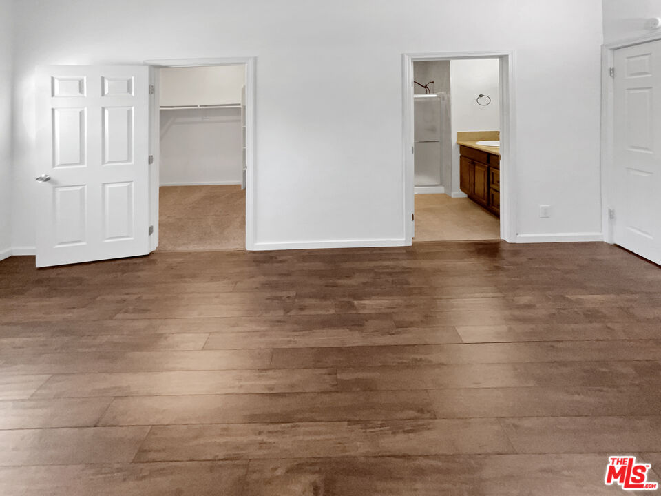 17530 Devonshire Street Northridge, CA 91325 - Photo 10 of 39 a view of a hallway with wooden floor and cabinets