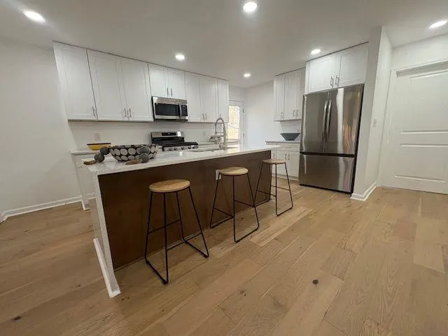 a kitchen with stainless steel appliances granite countertop a refrigerator stove microwave and sink