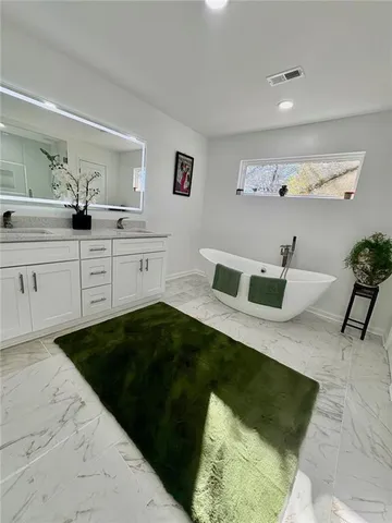 a spacious bedroom with a bed and a dresser in it