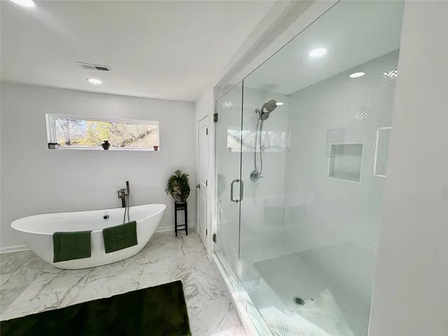 a bathroom with a tub sink a mirror and a shower