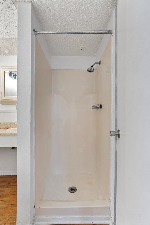 4103 Speedway, Unit 202 Austin, TX 78751 - Photo 8 of 13 Full bathroom with a textured ceiling, a shower, vanity, and wood finished floors