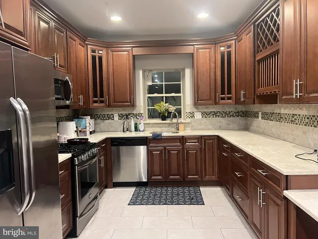 a kitchen with stainless steel appliances granite countertop a stove a sink dishwasher and a refrigerator