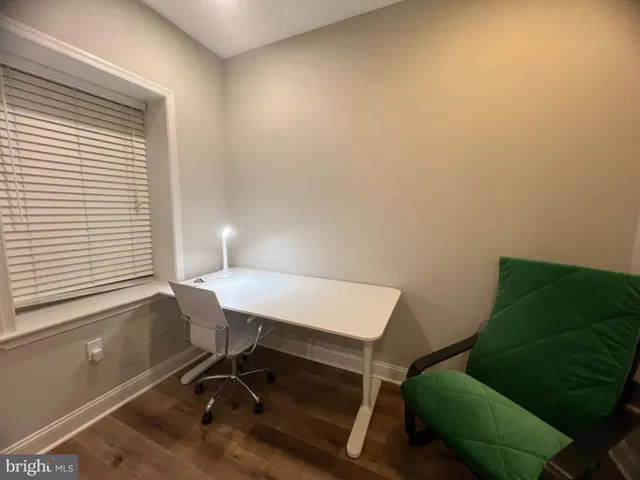 a view of a workspace with furniture and a window