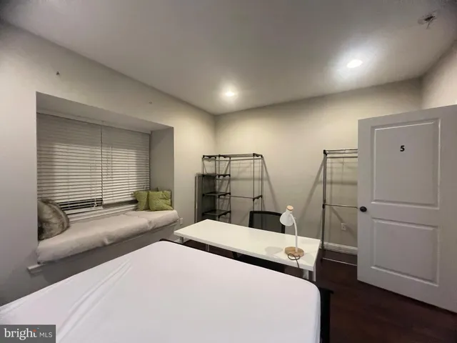 a bedroom with a bed and a large window