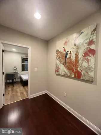 a view of a hallway with wooden floor and a ceiling fan