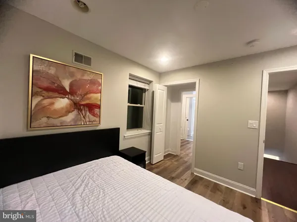 a bedroom with a bed and a painting on the wall