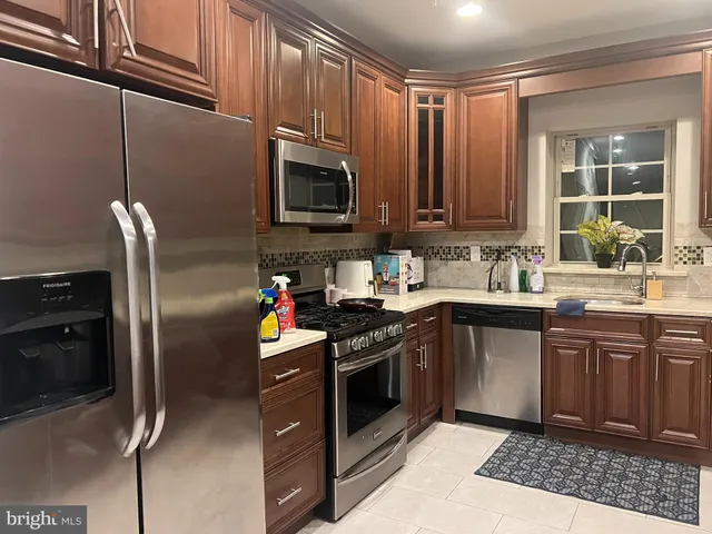 a kitchen with stainless steel appliances granite countertop a stove a sink dishwasher and a refrigerator