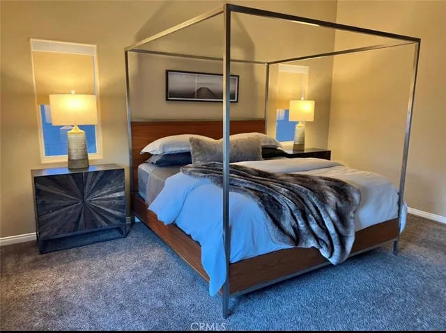 a bedroom with a bed a lamp and fan