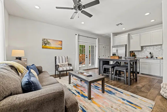a living room with furniture kitchen view and a window