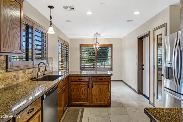 a kitchen with stainless steel appliances granite countertop a sink and a refrigerator