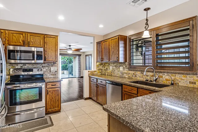 a kitchen with stainless steel appliances granite countertop a stove sink and cabinets