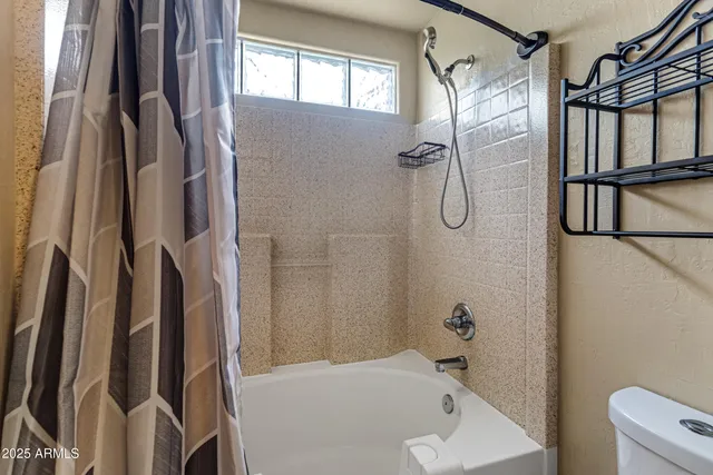 a bathroom with a tub shower vanity and a sink