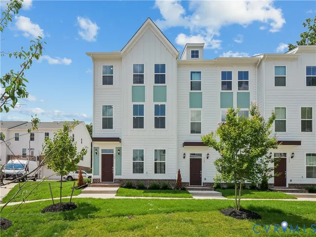 a front view of a house with a yard and trees