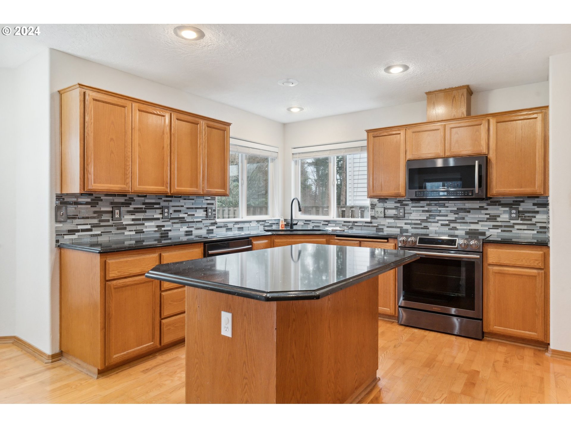 527 Southwest 27th Way Troutdale, OR 97060 - Photo 12 of 41 a kitchen with stainless steel appliances granite countertop a sink stove and refrigerator