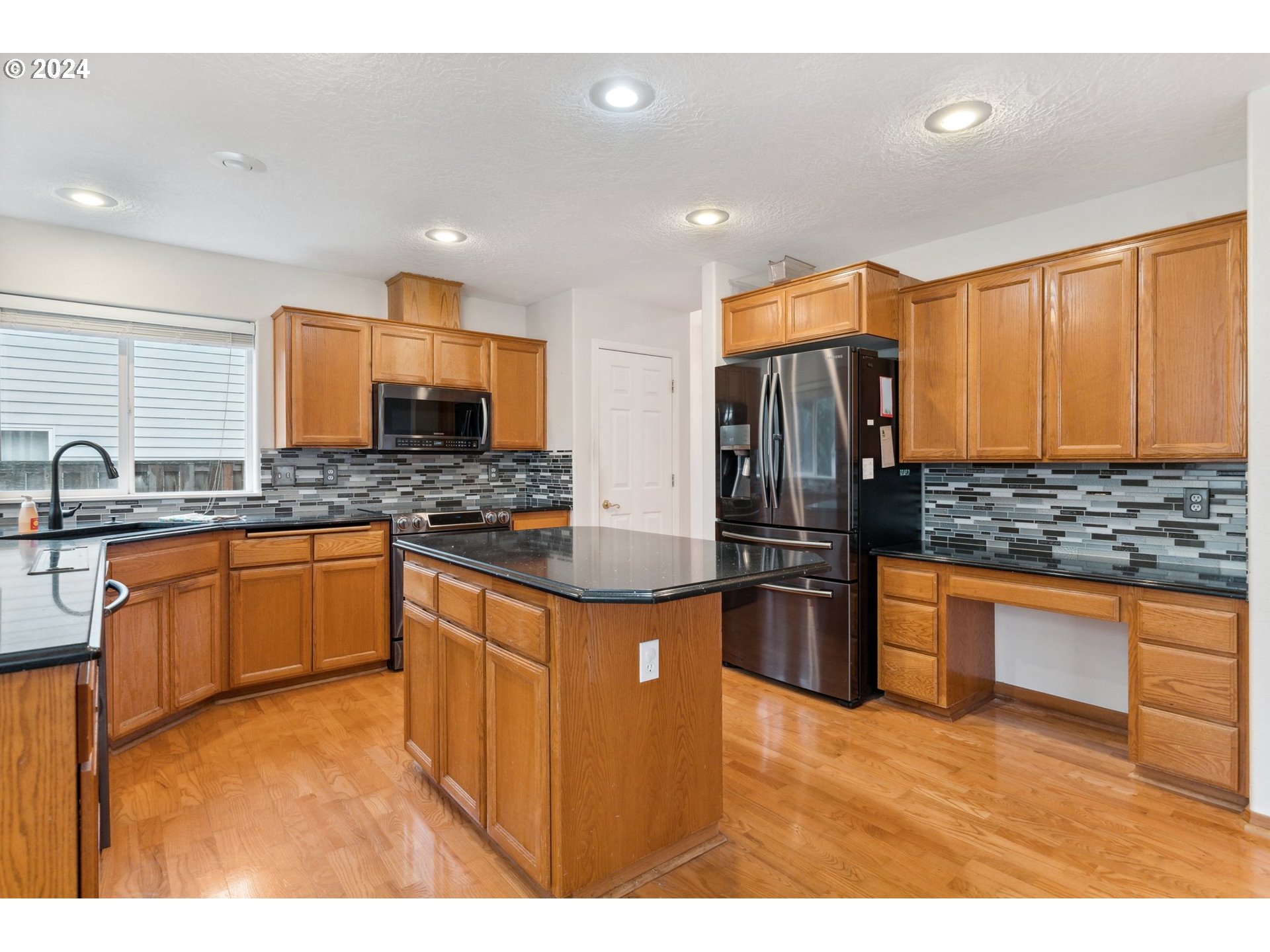 527 Southwest 27th Way Troutdale, OR 97060 - Photo 13 of 41 a kitchen with stainless steel appliances granite countertop a refrigerator and wooden cabinets