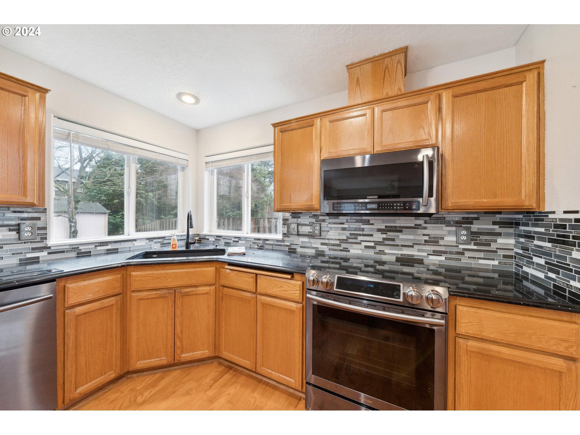 527 Southwest 27th Way Troutdale, OR 97060 - Photo 15 of 41 a kitchen with stainless steel appliances granite countertop a sink stove and microwave