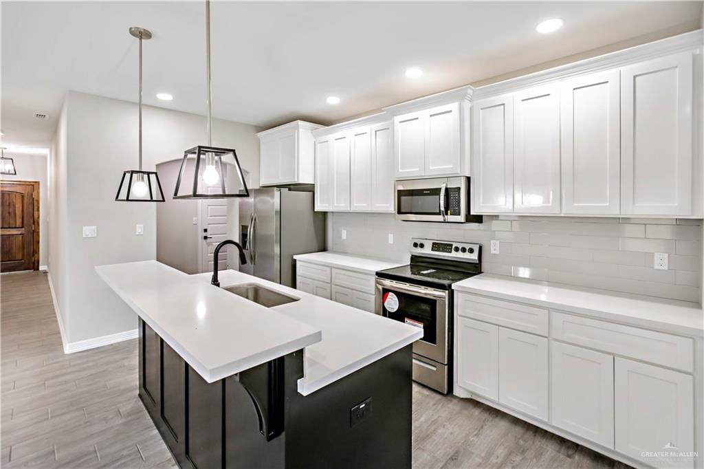 3710 Bea Avenue Harlingen, TX 78552 - Photo 3 of 14 a kitchen with kitchen island white cabinets appliances and sink