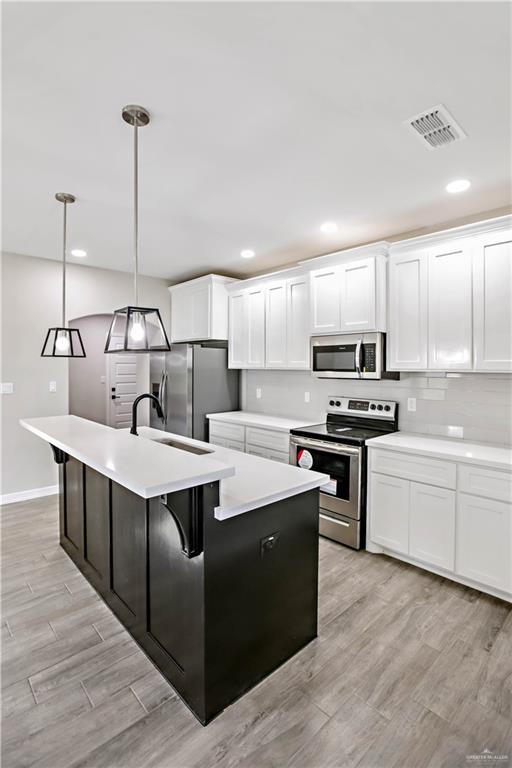 3710 Bea Avenue Harlingen, TX 78552 - Photo 4 of 14 a kitchen with kitchen island stainless steel appliances a sink a counter top space cabinets and a wooden floor