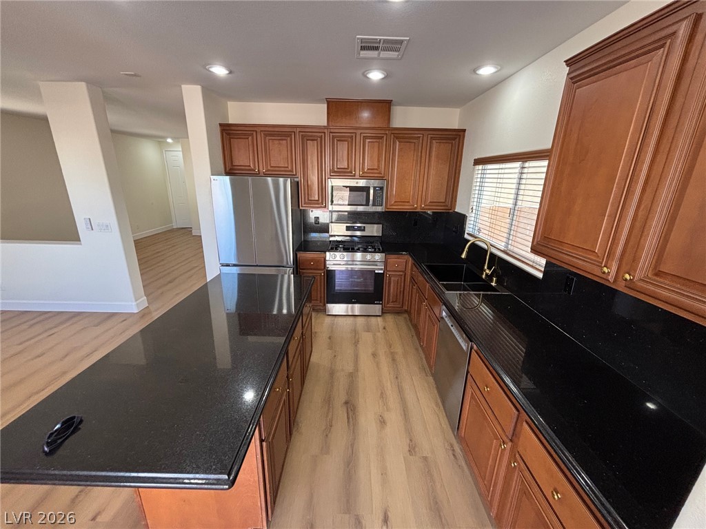 4900 Naff Ridge Drive Las Vegas, NV 89131 - Photo 5 of 21 A well-appointed kitchen features dark countertops, rich cabinetry, and modern stainless steel appliances.