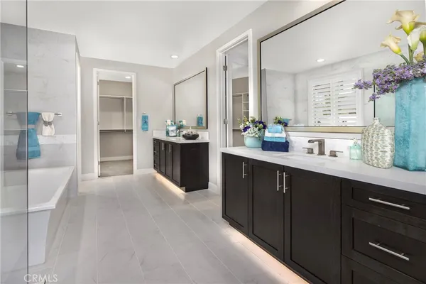 a large bathroom with a double vanity sink a large mirror and a bathtub