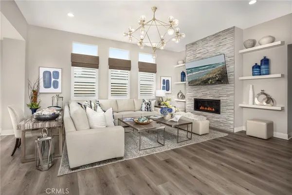 a living room with furniture a fireplace and a chandelier