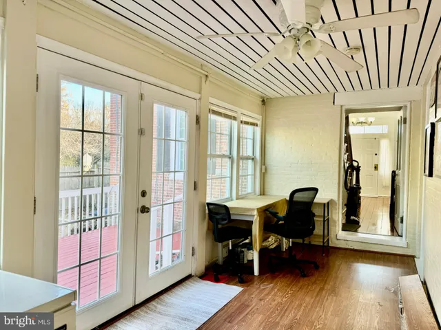 a living room with furniture a wooden floor and a large window