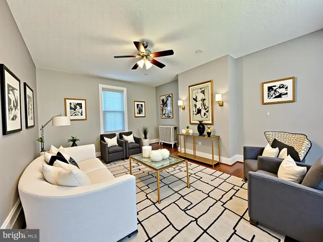 a living room with furniture and a ceiling fan