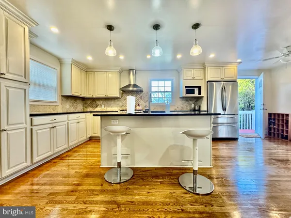 a kitchen with granite countertop a stove a sink and a refrigerator