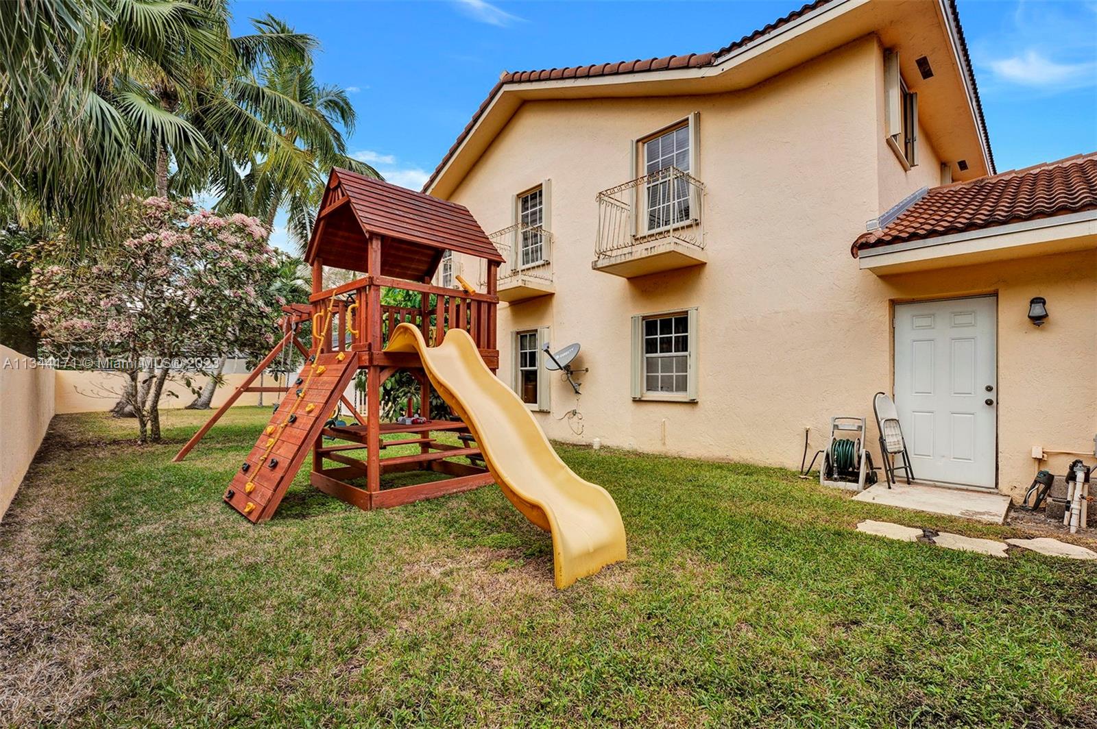 20100 Red Run Drive Hialeah, FL 33015 - Photo 52 of 61 a backyard of a house with childrens swings and slides