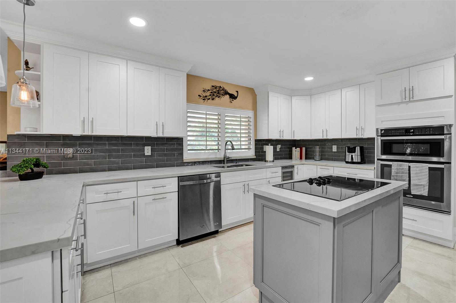 20100 Red Run Drive Hialeah, FL 33015 - Photo 9 of 61 a kitchen with stainless steel appliances granite countertop a sink stove microwave and cabinets