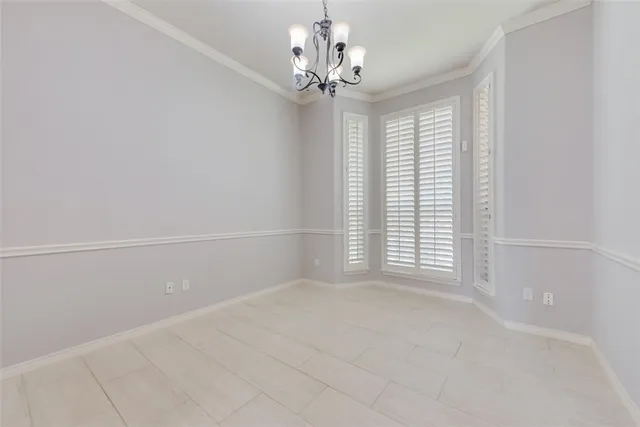 a view of a livingroom with a chandelier fan and windows