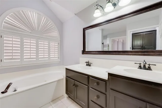 a bathroom with a sink a bathtub and a mirror
