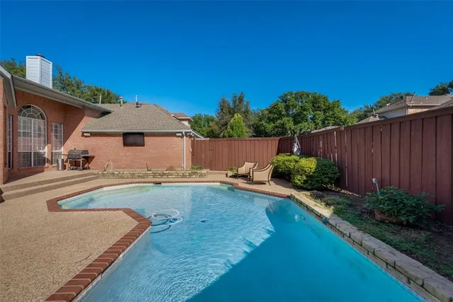 a view of a backyard with potted plants and wooden fence