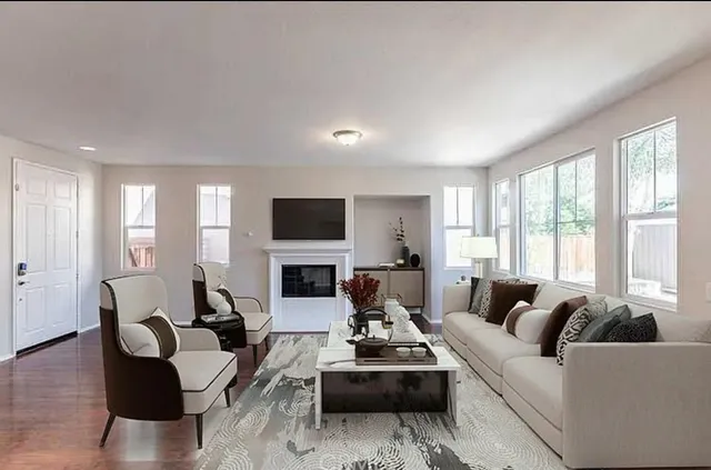 a living room with furniture flat screen tv and a large window
