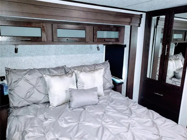 a bed sitting in a bedroom and mirror