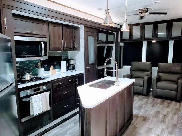 a kitchen with stainless steel appliances granite countertop a sink stove and microwave