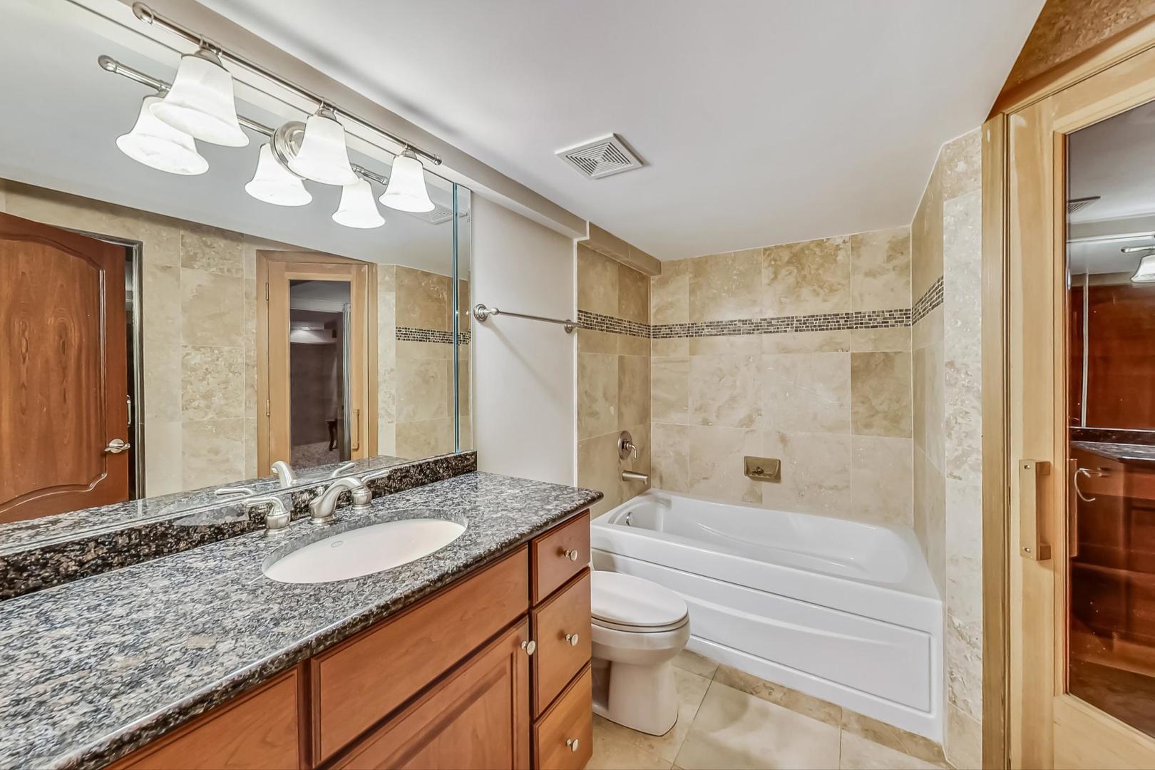 105 Fuller Road Hinsdale, IL 60521 - Photo 46 of 57 a bathroom with a granite countertop sink a toilet and shower