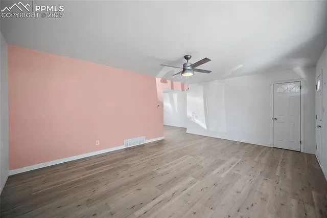 a view of an empty room with wooden floor
