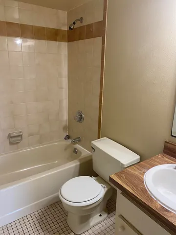 a white toilet sitting next to a bath tub and a shower