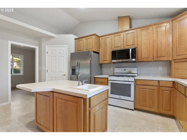 a kitchen with a sink a stove a microwave and refrigerator