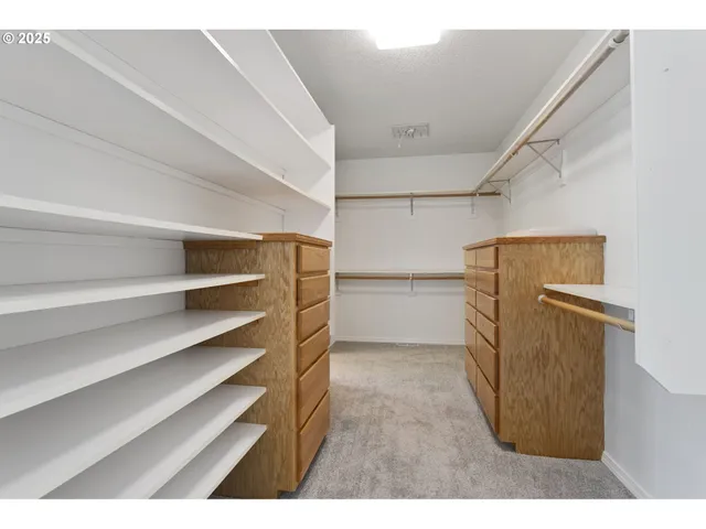 a view of walk in closet with empty racks