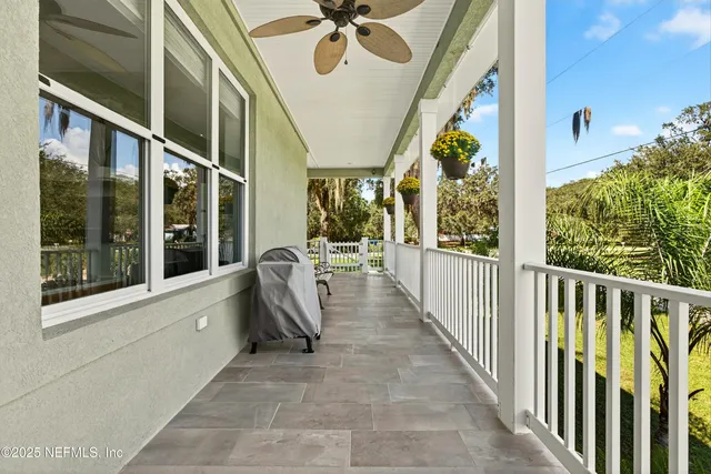 a bedroom with a bed a chair and a large window